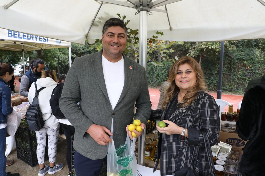 Ellerinde limon olan erkek ve kadın tezgahın önünde durup gülümseyerek kameraya bakıyor
