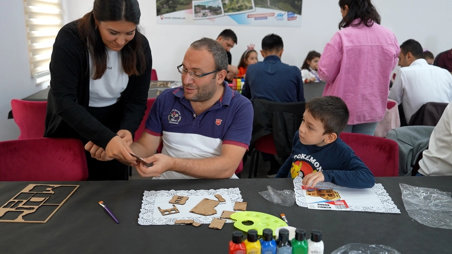 Çocuğuyla birlikte maket yaparken görevliden yardım isteyen bir baba